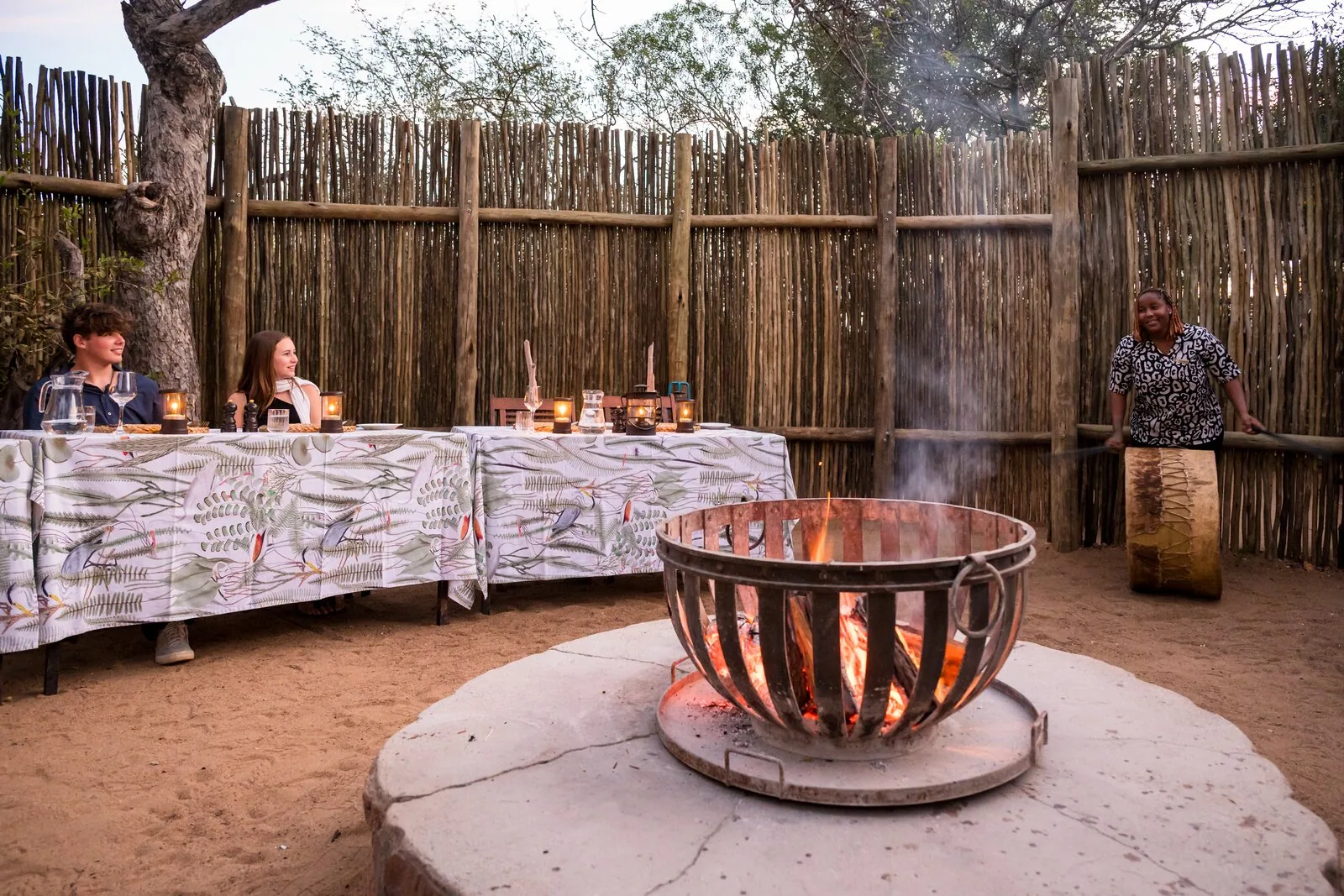 Copper fire bowl and a set boma table at dusk